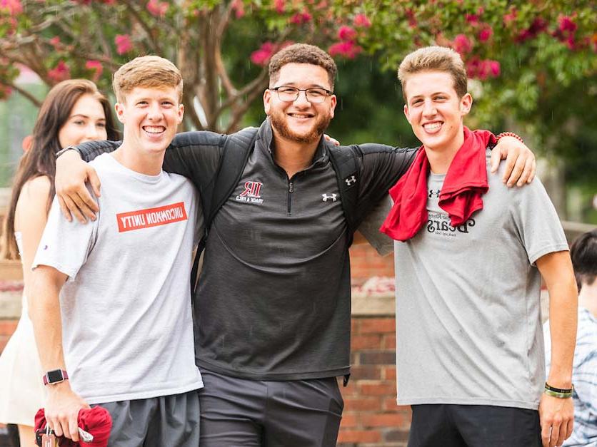 Three smiling students pose for a group photo