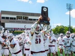 All-American and all-time scoring record holder Eric Dickinson ’21 holds up the South Atlantic Conference championship trophy. 