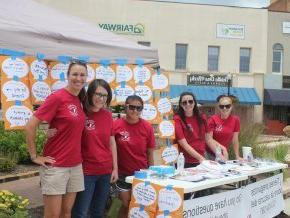 Taylor Newton, Ph.D., far right, stands with a group of student volunteers at an outdoor event.