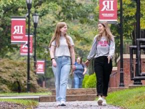 Students walking on sidewalk on campus between classes