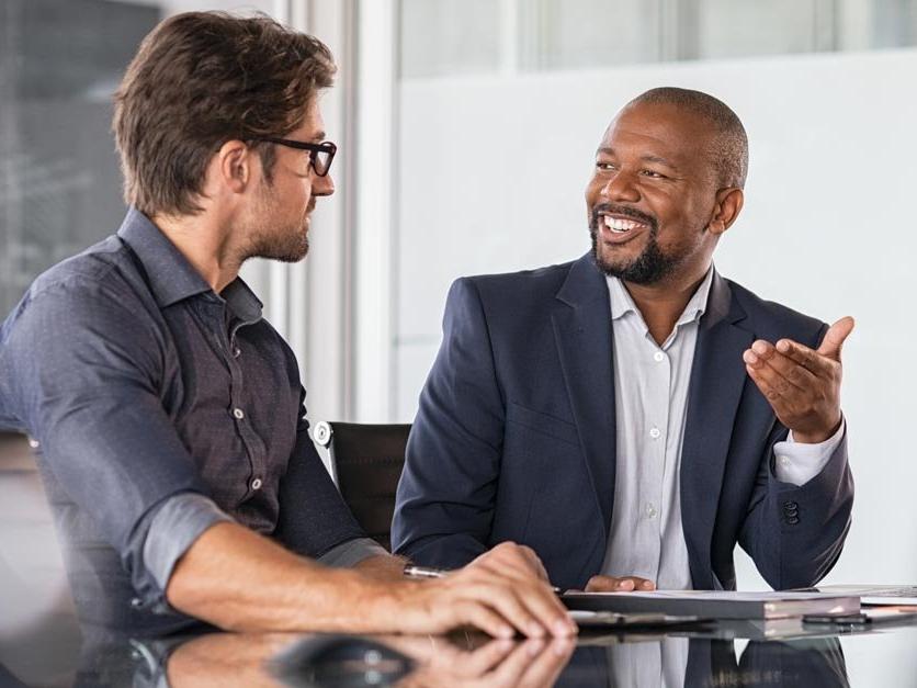 Two students discuss class project at table